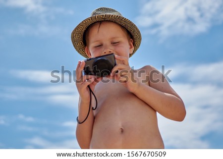 boy with a camera by the sea