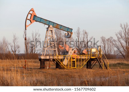 Oil rocking chair. Oil production in Russia, Republic of Bashkortostan. Industrial landscape. Autumn. Oil industry equipment.