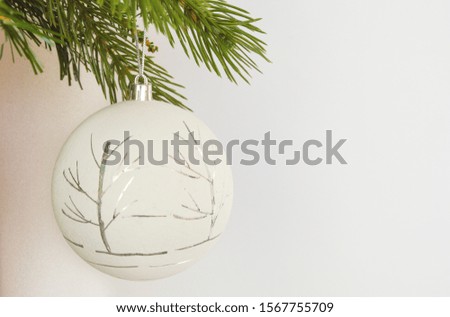 Christmas ball and tree branch on a white background. Merry Christmas and happy New year. Background for postcards for happy winter holidays.