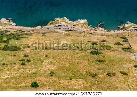 landscape. view of the coastal strip with buildings and yellow grass and a dark strip of the ocean