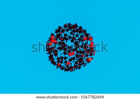 Red stars glitter confetti round shaped on blue background. Red glitter texture. Holiday new year backdrop. Anniversary, birthday. Greeting card template.