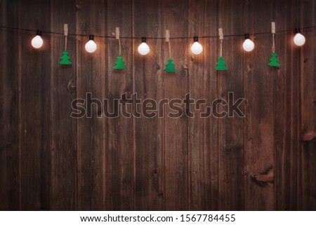 Wooden wall decorated by vintage electric lamps, Christmas or New years decoration background, space for add text or picture.