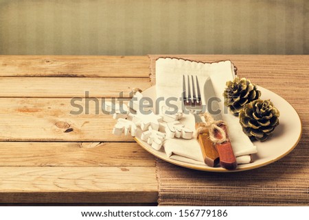 Retro style christmas table setting with plate, knife, fork and wooden ornaments