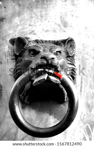 An iron lion head with a big ring in the mouth, black and white 
