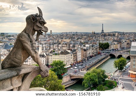 Gargoyle on Cathedral of Notre Dame de Paris, France. Gothic gargoyle (chimera) on city background. Panorama of Paris with demon statue at sunset. View of Paris from above, town skyline in summer.