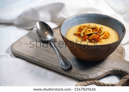 Yellow pea soup on a white rustic background