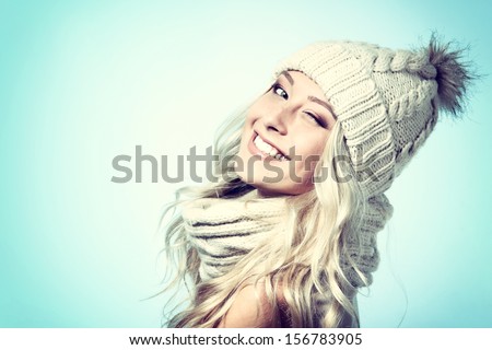 christmas girl, young beautiful smiling and give a wink over blue background