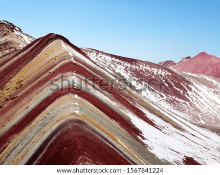 Views from the peak of the Vinicunca mountain, known as Rainbow mountain in Peru. Beautiful place at 5000 meters of altitude in Andes Cordillera, Cusco region in South America. Snow scene with clouds.