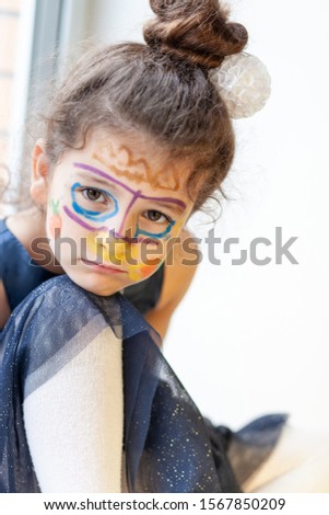 Portrait of a sad girl with painted face looking at the camera