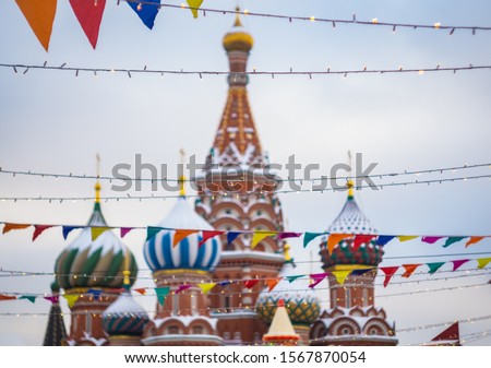 A blurred picture of a famous cathedral in Moscow in the background and festive colourful garland in the foreground 