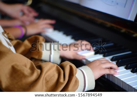 Close-up of a music performer's child hand playing the piano