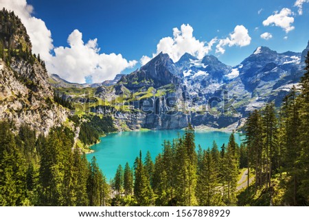 Oeschinnensee lake with waterfalls and Swiss Alps, Kandersteg, Berner Oberland, Switzerland. Royalty-Free Stock Photo #1567898929