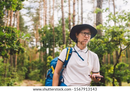 Girl tourist use smartphone on hike, looks maps and navigation. Woman with backpack using smart phone on beautiful nature.Travel concept. Outdoor travel. Travel and explore. Female Tourist Using gps.