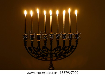 Hanukah menorah candles lit and burning at night