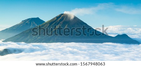 Mount Sindoro and Sumbing surrounded by the smooth clouds , seen from Mount Prau, Wonosobo Regency, Central Java, Indonesia Royalty-Free Stock Photo #1567948063