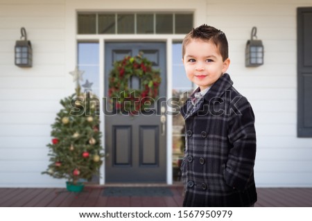 Young Mixed Race Boy On Front Porch of House with Christmas Decorations.