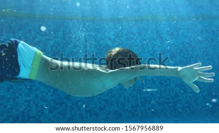 Boy swimming underwater at the pool
