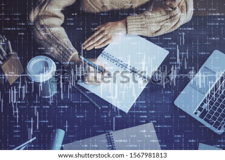 Forex graph on hand taking notes background. Concept of research. Double exposure