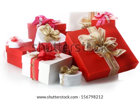 Collection of ornamental red and white gifts in different sizes and shapes tied with decorative gold and red ribbon and bows for celebrating Christmas, Valentines, birthday or an anniversary, on white