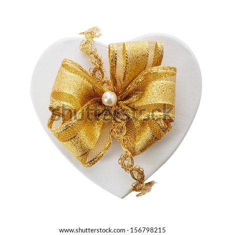 Romantic heart shaped gift and gold bow fastened with a pearl and braid for a loved one or sweetheart on Christmas, Valentines, birthday or an anniversary, overhead isolated on white