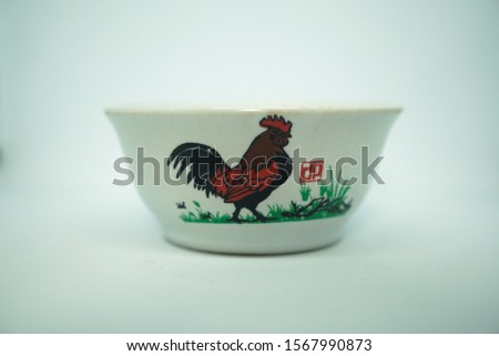 The white bowl with cockpainted on it on the white background