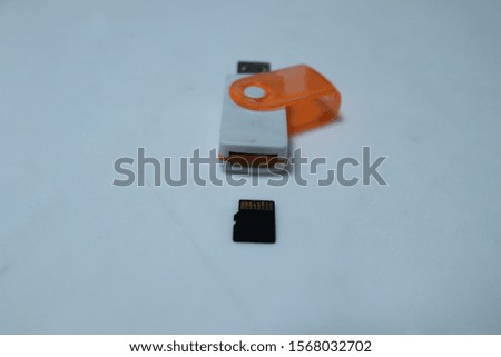 SD card in hand and card reader on table