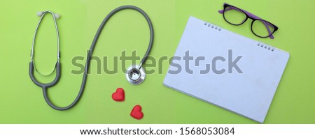Top view with copy space, flat lay. red heart stethoscope and notebook , Glasses on desk doctor