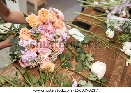 European floral shop concept. Florist woman creates beautiful bouquet of mixed flowers. Handsome fresh bunch. Education, master class and floristry courses. Flowers delivery.