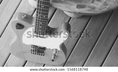 vintage electric guitar on the wooden boards closeup . black and white                             