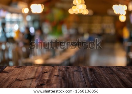 Wooden table on a restaurant blurred background is an abstract background.