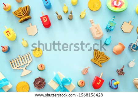 religion image of jewish holiday Hanukkah with menorah (traditional candelabra), spinning top over wooden blue background. top view, flat lay