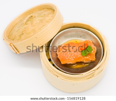 Chinese steamed dim sum salmon fish in bamboo container traditional cuisine isolated on white background in thai restaurant at Thailand