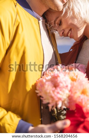 Close up picture of smiling young lady leaning on shoulder of her boyfriend