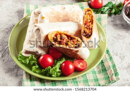 Burritos wraps with mincemeat, beans and vegetables. Mexican dish