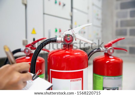 Engineer are inspection Fire extinguisher in fire control room for emergency, rescue and safety Concept.