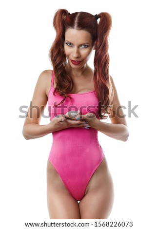 The girl in a pink bathing suit holds a small mouse in the palms
