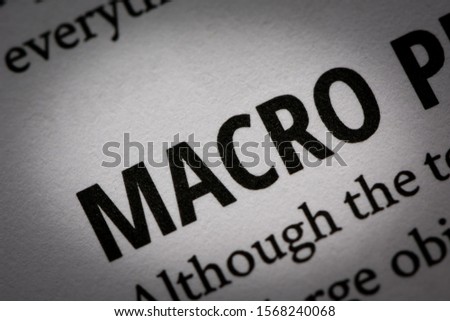Macro photograph of word "macro" in white page of a book about photography with small vignette applied.