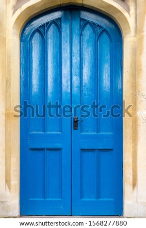 Blue wooden church door with a stone arch