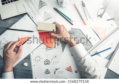 Graphic designer drawing sketches logo design. The concept of a new brand. Professional creative occupation with idea. Royalty-Free Stock Photo #1568279158