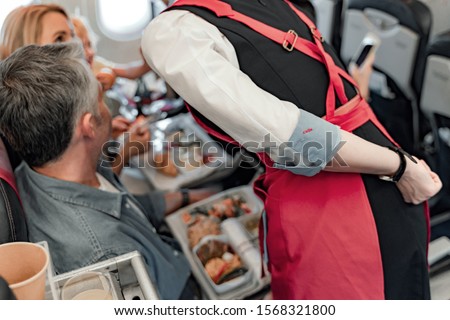 Young man and woman is sitting in plane stock photo
