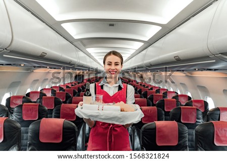 Waist up of happy air hostess with food tray stock photo