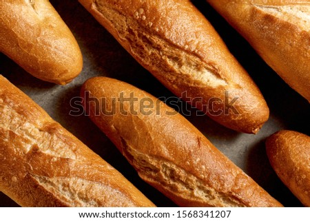 Homemade cakes. Freshly baked french baguettes on a gray stone surface. Top view.