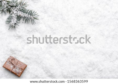 Christmas background with snow, christmas gift and fir tree branch, flat lay, top view