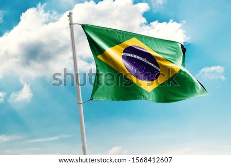 Waving Flag of Brazil in Blue Sky. Brazil Flag on pole for Independence day. The symbol of the state on wavy cotton fabric. Royalty-Free Stock Photo #1568412607
