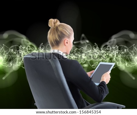 Composite image of businesswoman sitting on swivel chair with tablet on black background with green lightening