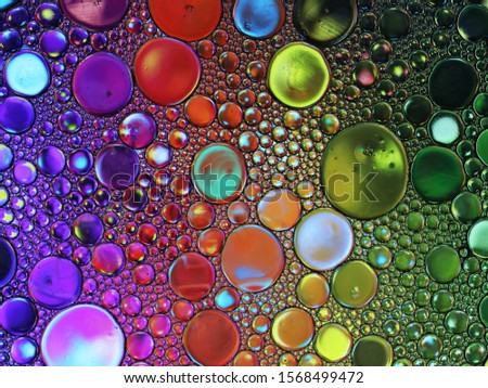 Abstract multicolor water oil soap bubbles mixed texture with micro 
stars. Colorful background. Close-up shot. Rainbow oil pattern and texture 