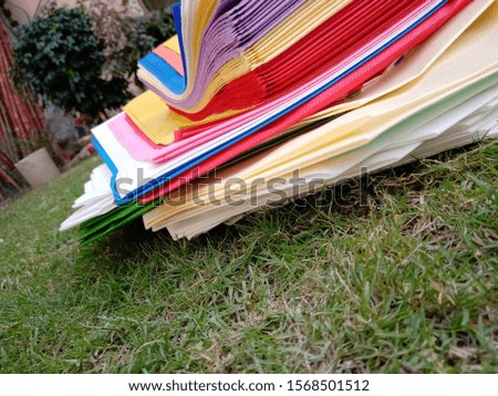 Multicolored isolated Non Woven Bags on Green Grass