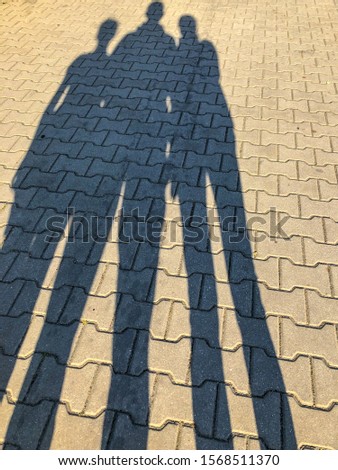Shadow of family on the grond in sunny day.