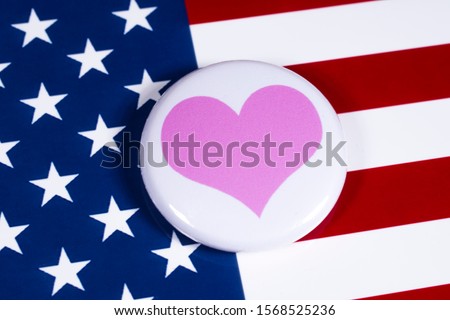 A pink heart symbol, pictured over the flag of the United States of America.