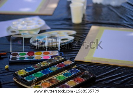 Watercolors and white paper. Start painting with water colors. Preparing for artwork.